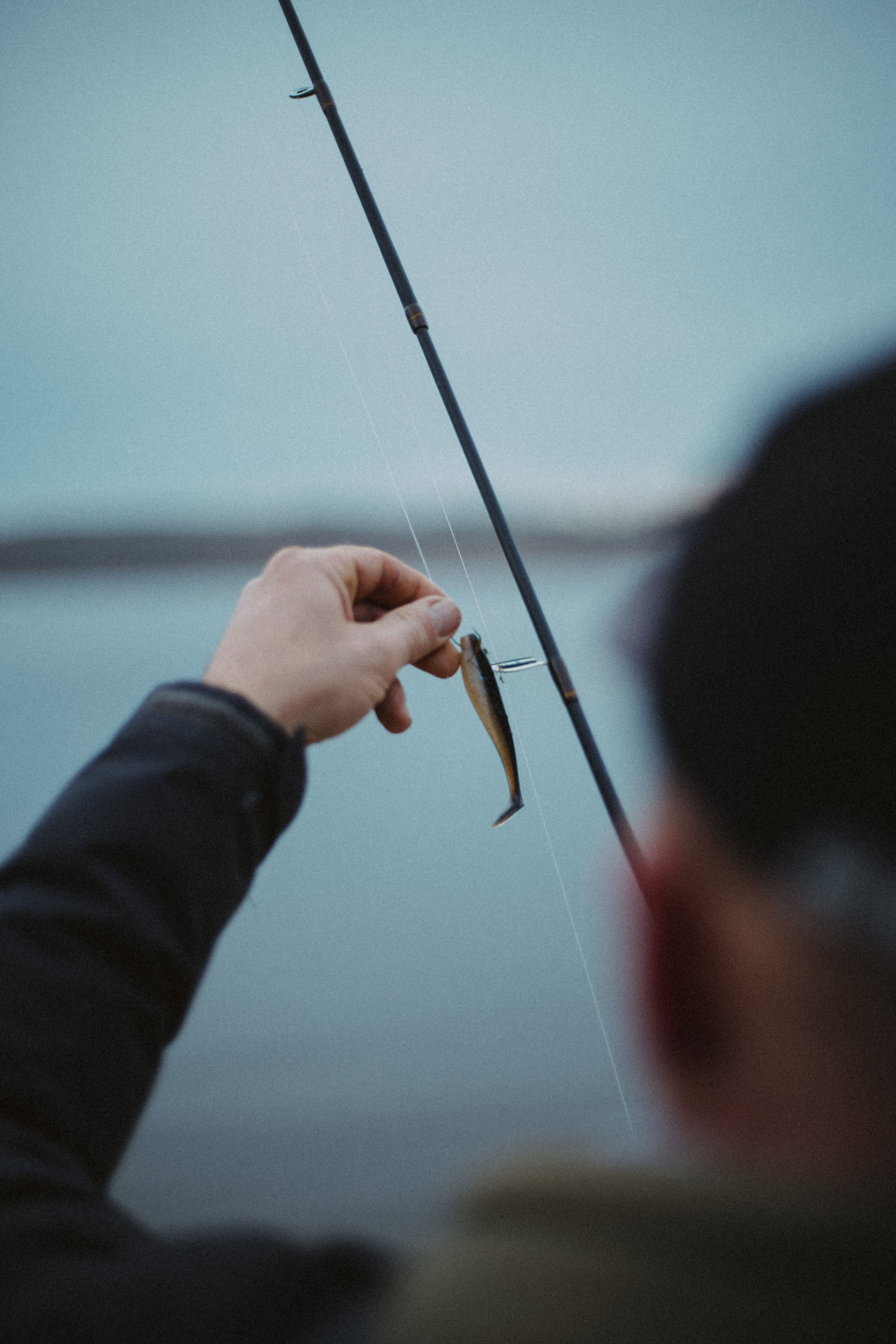Sea fishing at sunrise on rocky shoreline in Norway