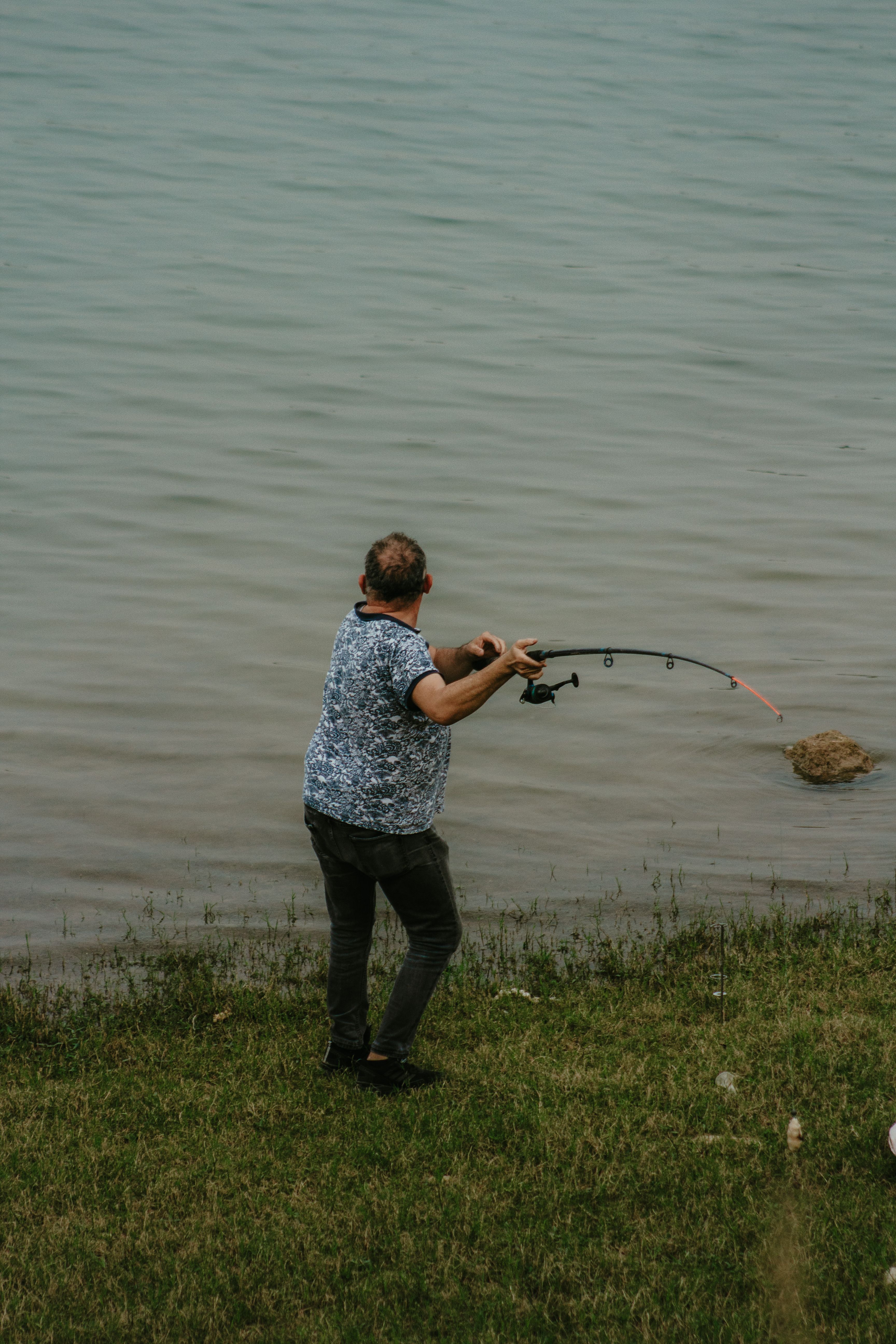Fisherman casting from lakeshore